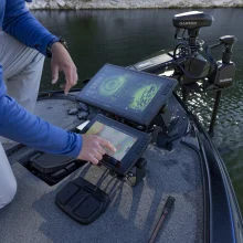 Detailný zbáer na muža, ktorý používa sonar Garmin na člne, na jazere.